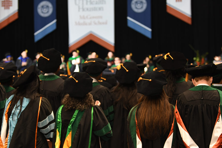 Members of the McGovern Medical School Class of 2026 stand during the commencement ceremony at NRG Arena.