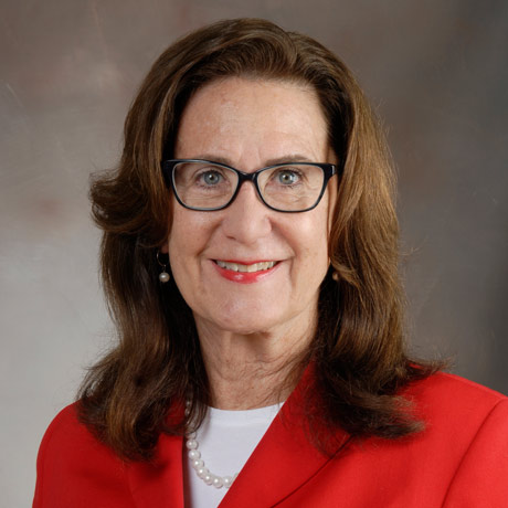 Dr. Claire E. Hulsebosch poses for a headshot in a red blazer with white shirt