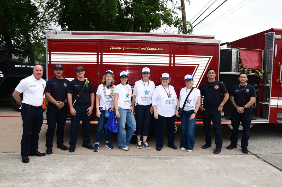 LoneStar LEND participants and local first responders pose together in front of a fire truck during the Disaster Readiness EXPO focused on inclusive emergency preparedness.