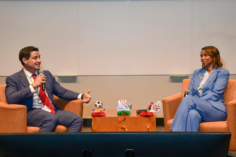 Michael Patriarca, left, and LaTanya Love, MD, right, participate in a Dean’s Dialogue discussion while seated onstage with microphones during a campus event.