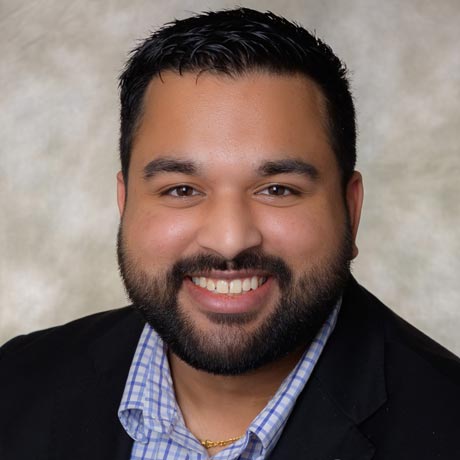 Likhit Agrawal poses for a professional headshot in a black jacket and blue button up shirt