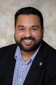 Likhit Agrawal poses for a professional headshot in a black jacket and blue button up shirt