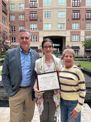 Dr. Kevin Morano, left, stands with inaugural Leslie Beckman Award recipient Lierni Ugartemendia, PhD, center, and Leslie Beckman, right, during an outdoor recognition ceremony. Ugartemendia holds her Beckman Award certificate, which honors exceptional service and dedication to the postdoctoral community at UTHealth Houston.