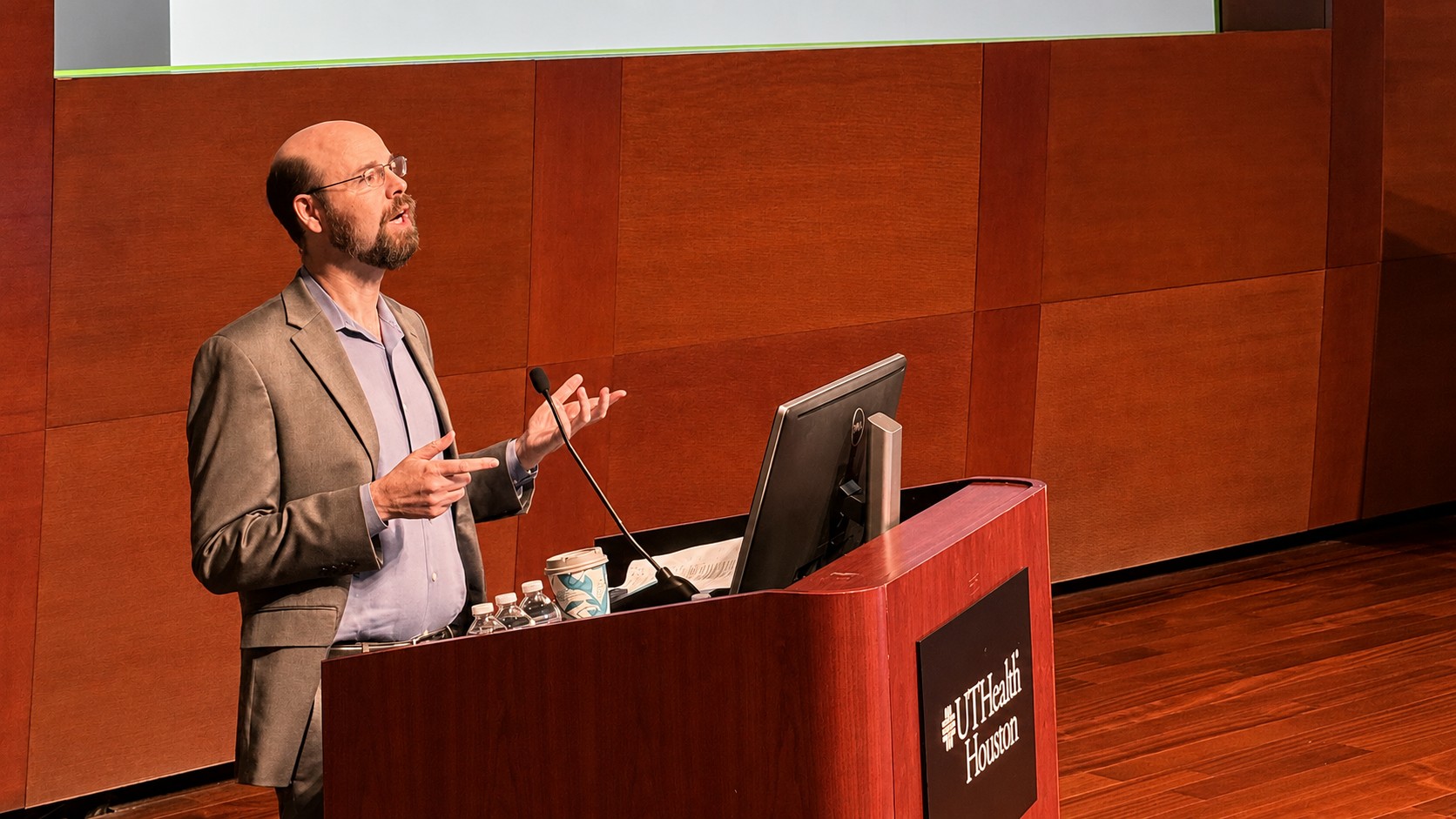 Dr. Sean Savitz presents at a lectern with the UTHealth Houston logo at the annual Yatsu Day Symposium