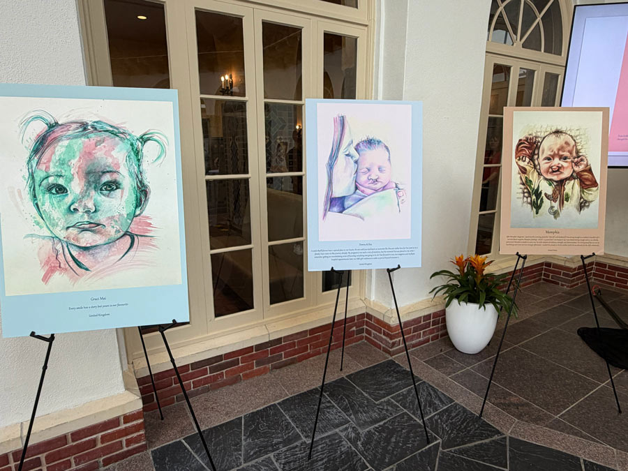 Three colorful portraits of infants born with cleft differences displayed on easels as part of the 100 Cleft Portraits Tour.