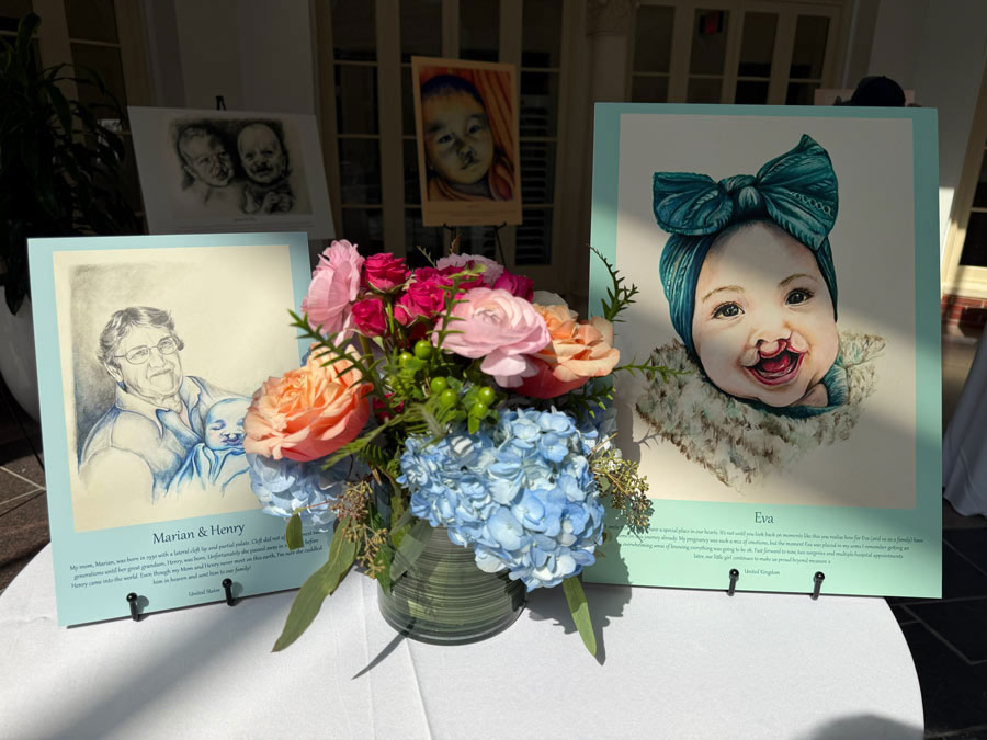 Portraits of children and families affected by cleft differences surround a colorful floral arrangement during the 100 Cleft Portraits Tour.