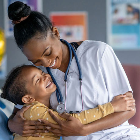 A nurse hugs a pediatric patient